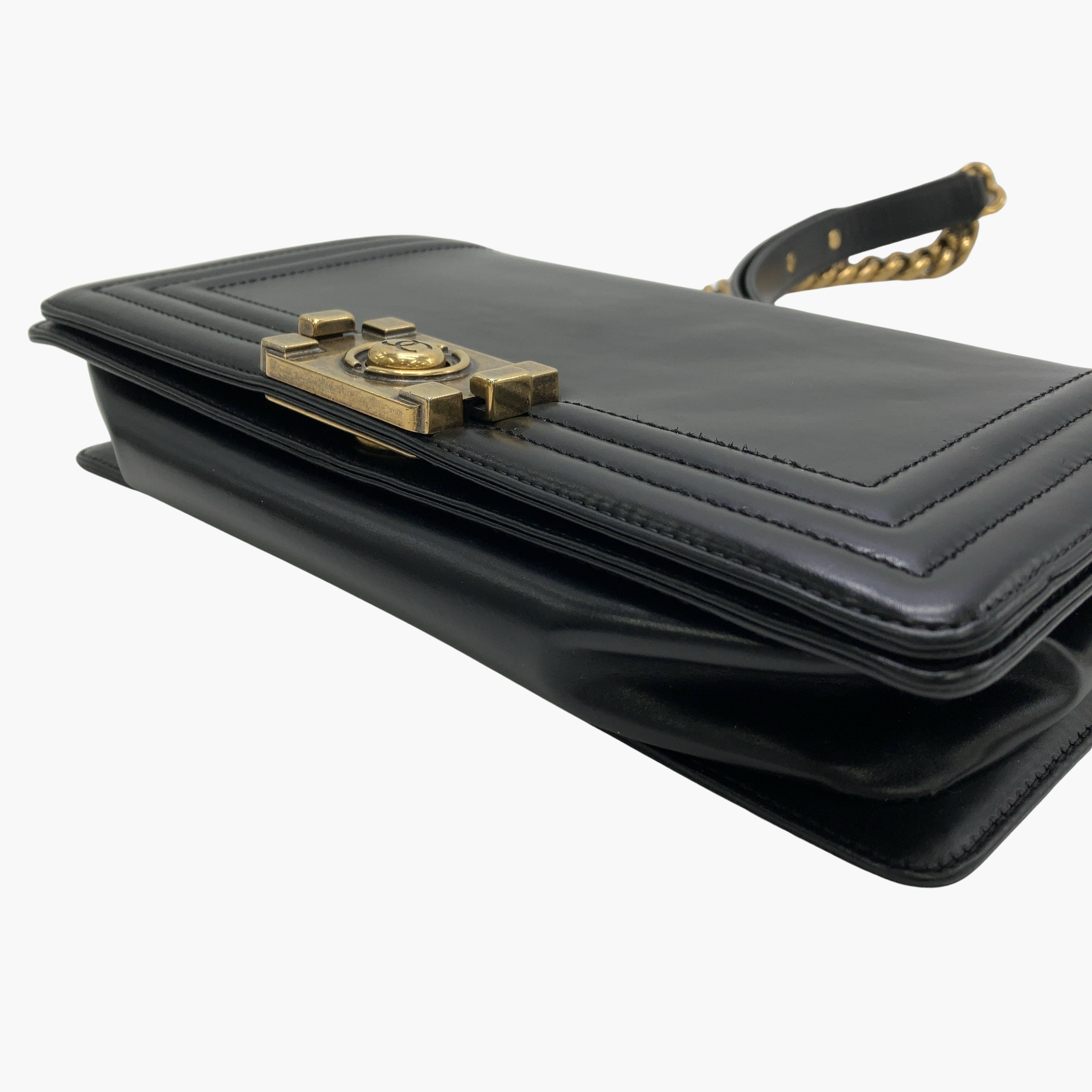 Sort Chanel Boy-håndtaske, der ligger fladt på siden