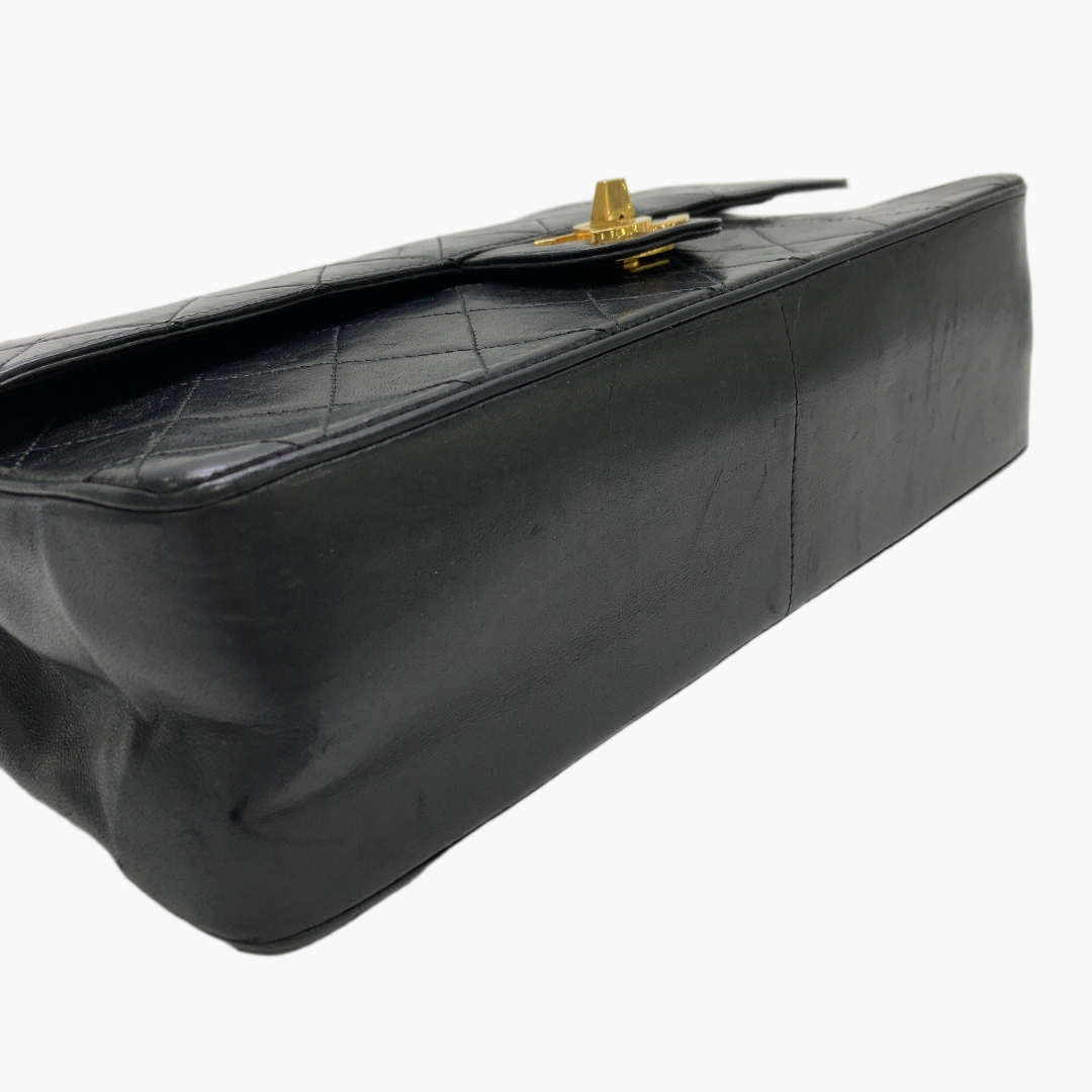 Chanel Classic Flap Medium ligger fladt på siden med en glat læderbund